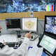A police officer watches a television monitor displaying a fraction of London’s CCTV camera network